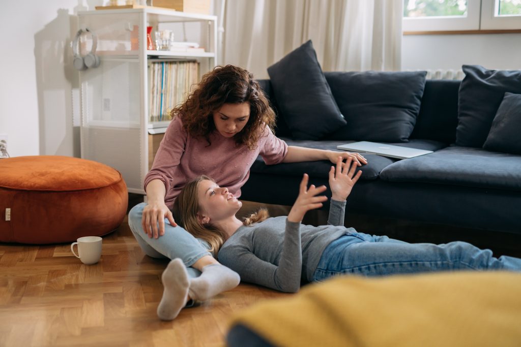 mother and daughter talking, sitting on floor in living room