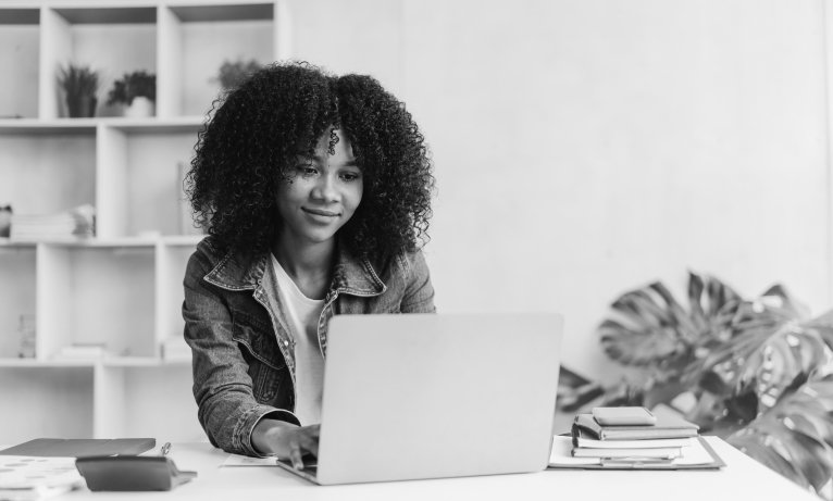 young woman working on a laptop in an office setting